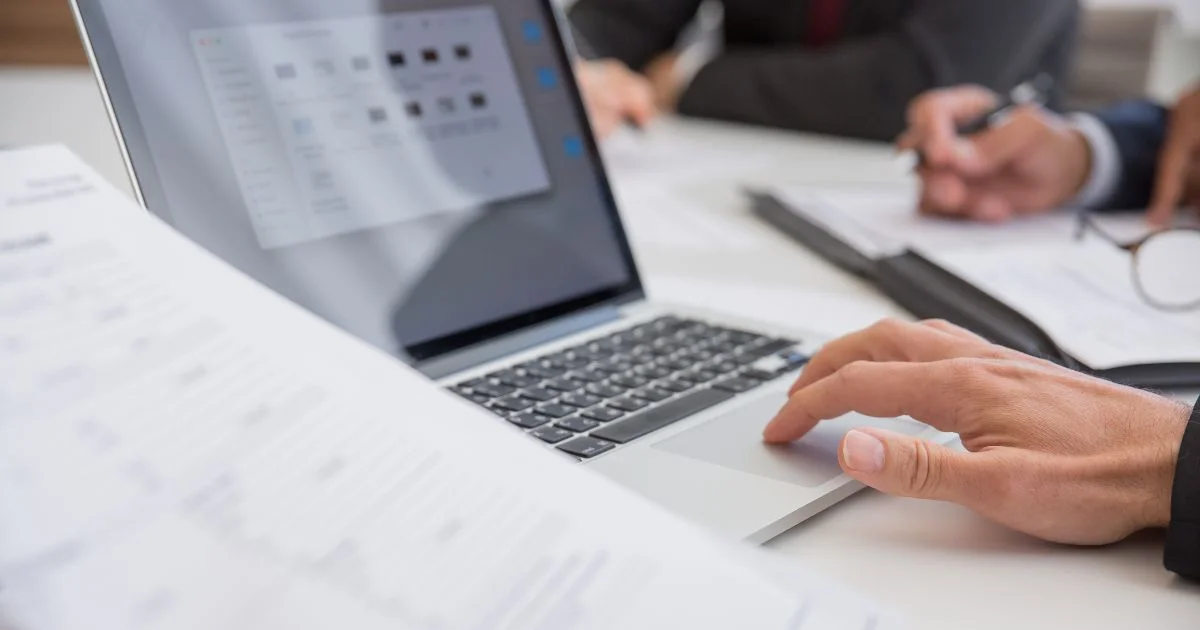 Hands using a laptop during a business meeting