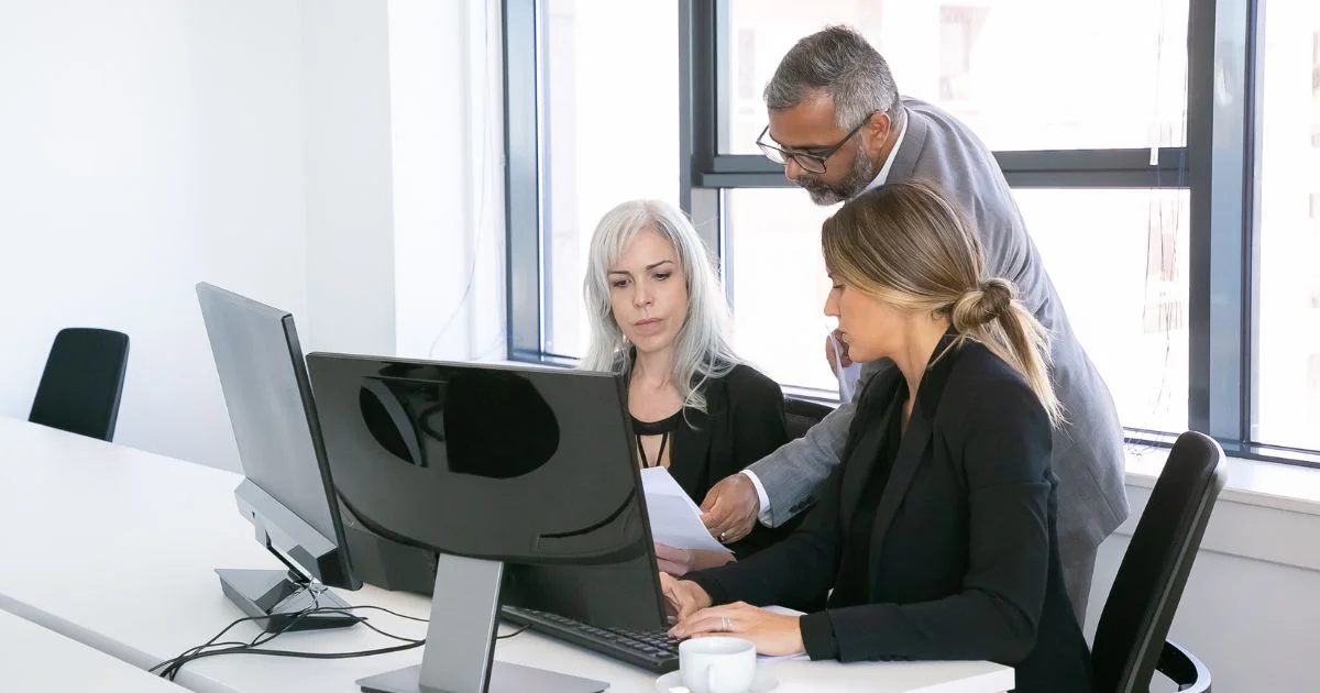 Business team reviewing documents at computer