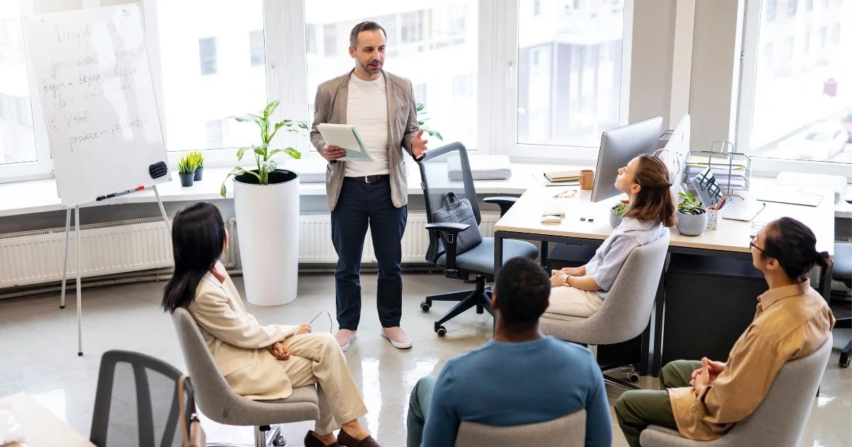 Manager leading staff training session in office meeting room